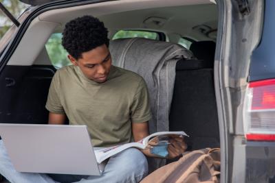 Student with laptop in car